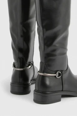 Bottes plates montantes jusqu'aux genoux aux détails de ferrures imposantes