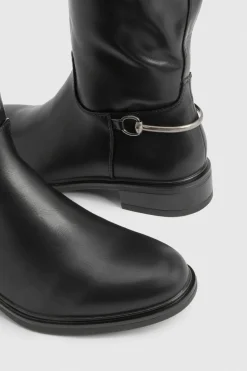 Bottes plates montantes jusqu'aux genoux aux détails de ferrures imposantes