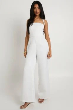 Combinaison une-pièce en satin premium, corset à baleines, à encolure halter et jambes larges.