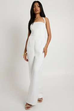 Combinaison une-pièce en satin premium, corset à baleines, à encolure halter et jambes larges.