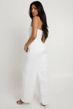 Combinaison une-pièce en satin premium, corset à baleines, à encolure halter et jambes larges.