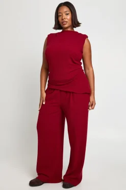 Haut avec épaulettes, détails plissés, ourlet asymétrique et pantalon à jambes larges