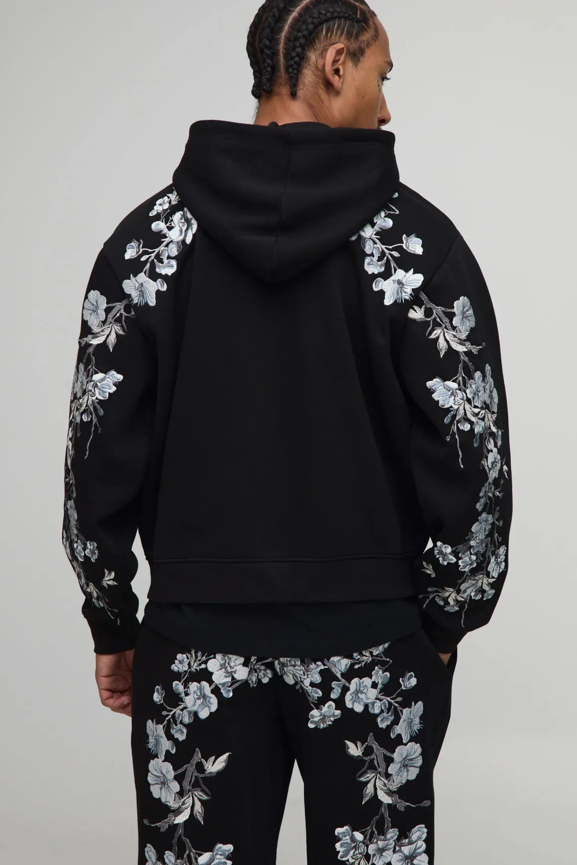 Hoodie à capuche oversize et cubique, avec surpiqûres apparentes, broderie florale et fermeture éclair intégrale.