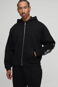 Hoodie à capuche oversize et cubique, avec surpiqûres apparentes, broderie florale et fermeture éclair intégrale.