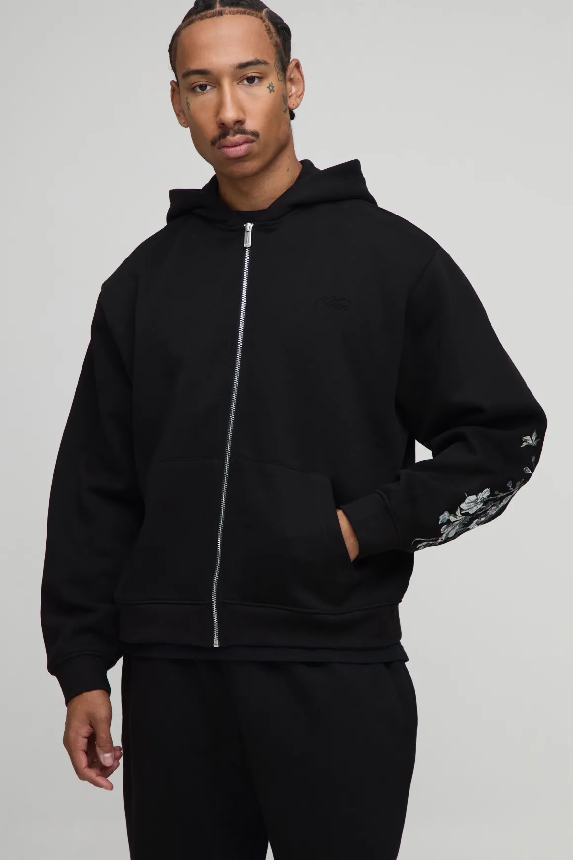 Hoodie à capuche oversize et cubique, avec surpiqûres apparentes, broderie florale et fermeture éclair intégrale.