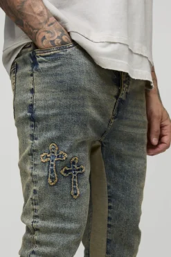 Jeans skinny longs empilés avec applique croisée et empiècement