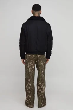 Pantalon cargo ample à fines rayures, avec surpiqûres et imprimé camouflage.