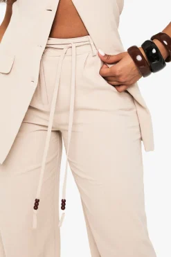 Pantalon à jambe large en lin orné de perles et à détails noués