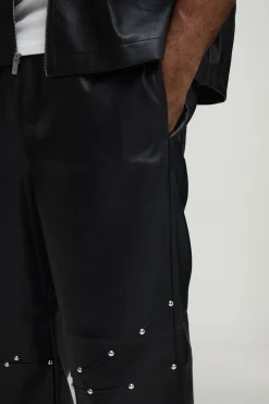 Pantalon à l'aspect cuir clouté, ourlet zippé, coupe décontractée