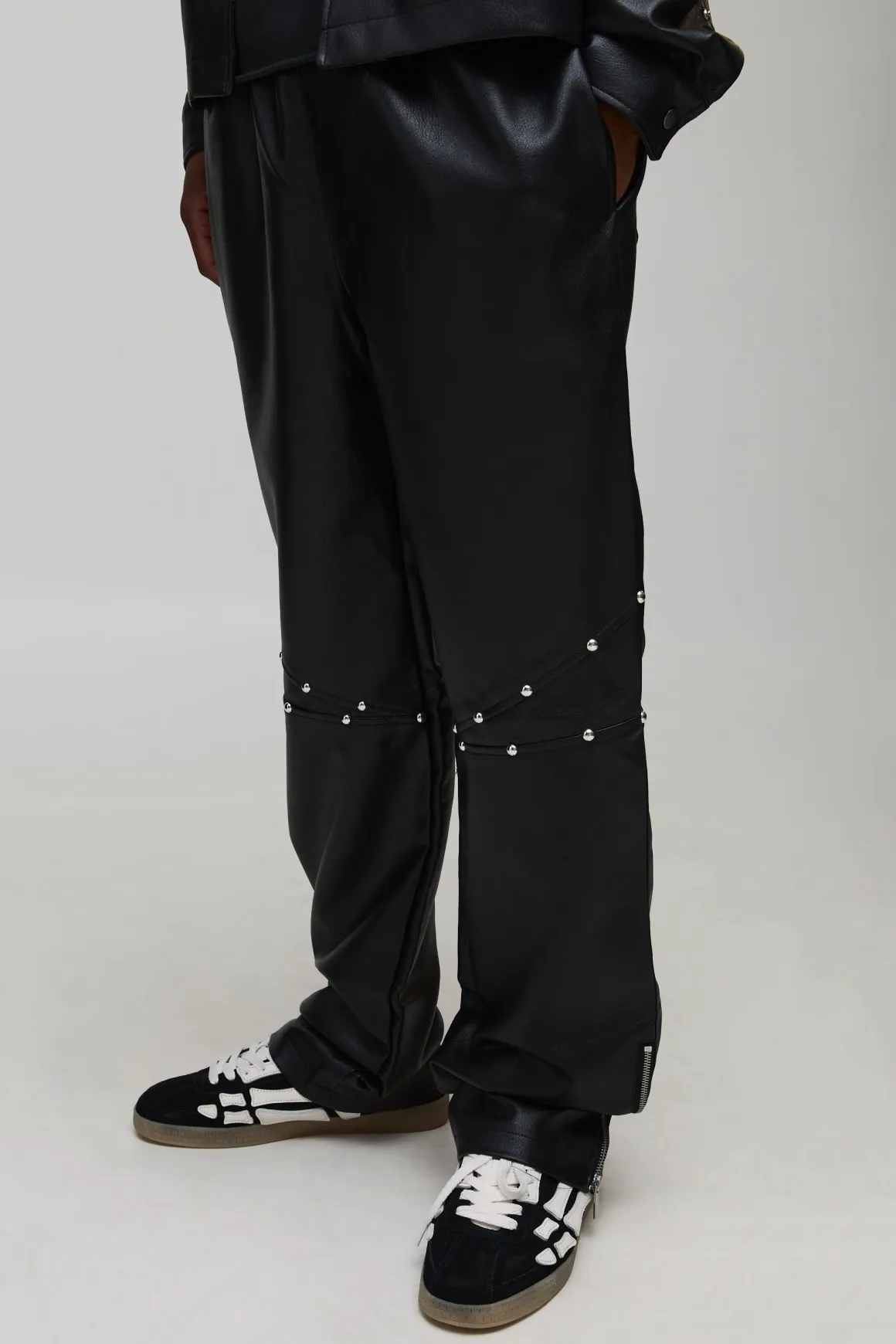 Pantalon long clouté à l'aspect cuir, ourlet zippé et coupe décontractée
