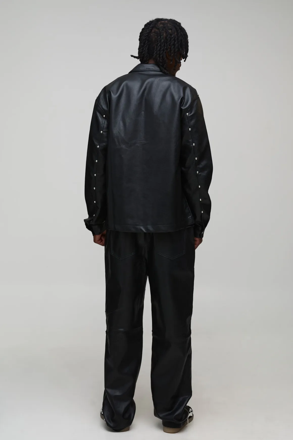 Pantalon long clouté à l'aspect cuir, ourlet zippé et coupe décontractée