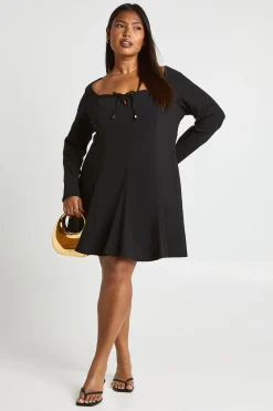 Robe à détails dorés, devant noué, ourlet à godet