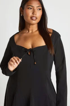 Robe à détails dorés, devant noué, ourlet à godet