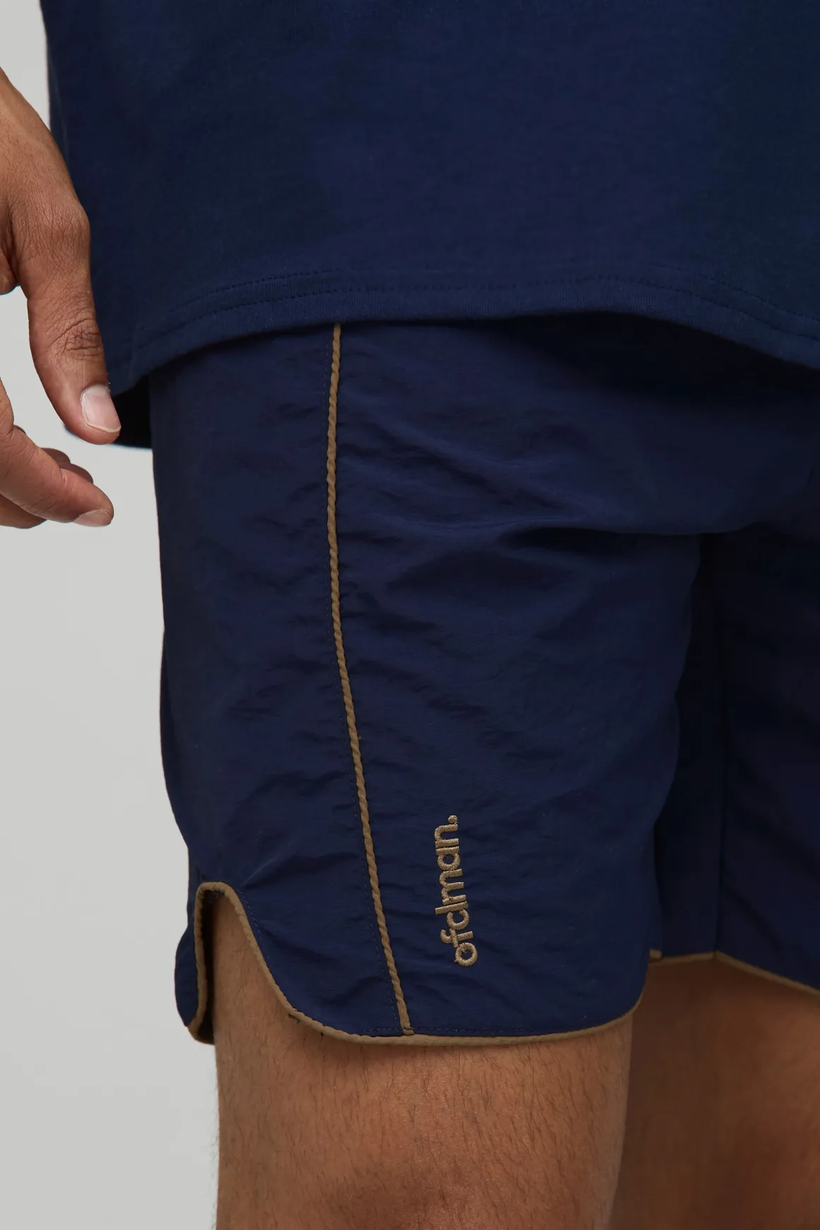 Shorts en nylon froissé à taille élastiquée avec passepoil