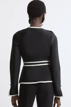 Veste en maille à ourlet fendu, effet bandage sculptant la silhouette, avec passepoils contrastés militaires.