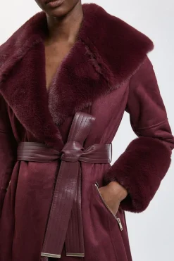 Veste midi ceinturée à col et aux poignets en fausse shearling
